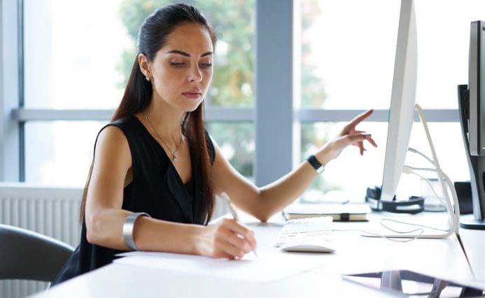 branding-strategy-agency-best-practices Skilled worker points to screen while taking notes