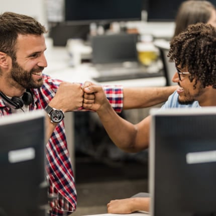 Two colleagues fist-bump after completing a task