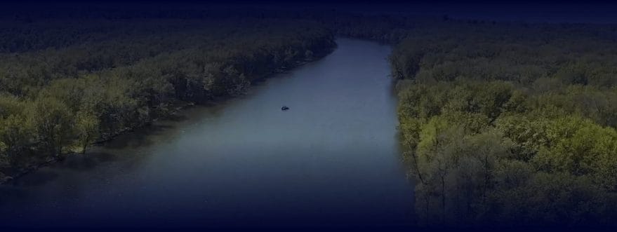 headwaters-background A river surrounded by green trees