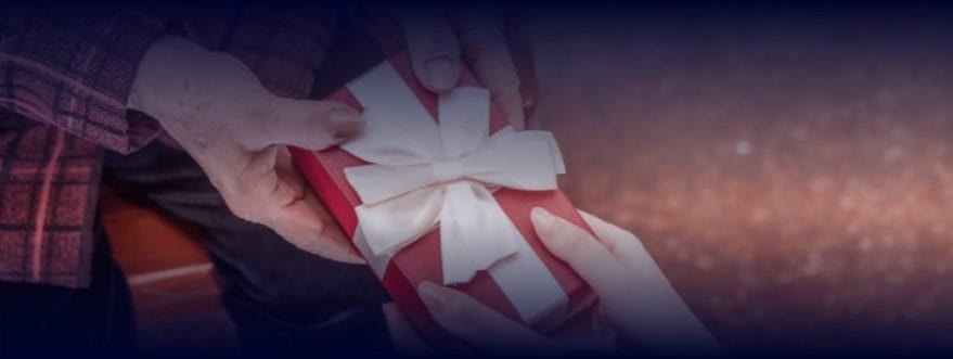 arnold_jewelers_background_2 Old and young hands hold a gift together