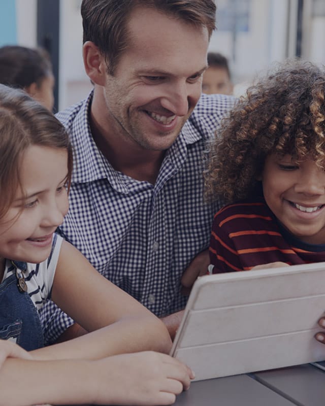 A man and two kids studying together
