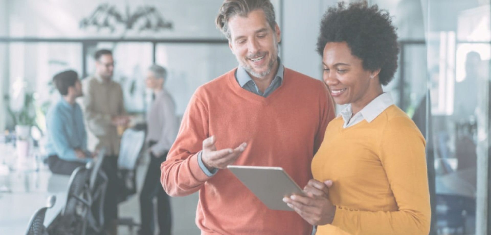 a man and a woman looking at a tablet