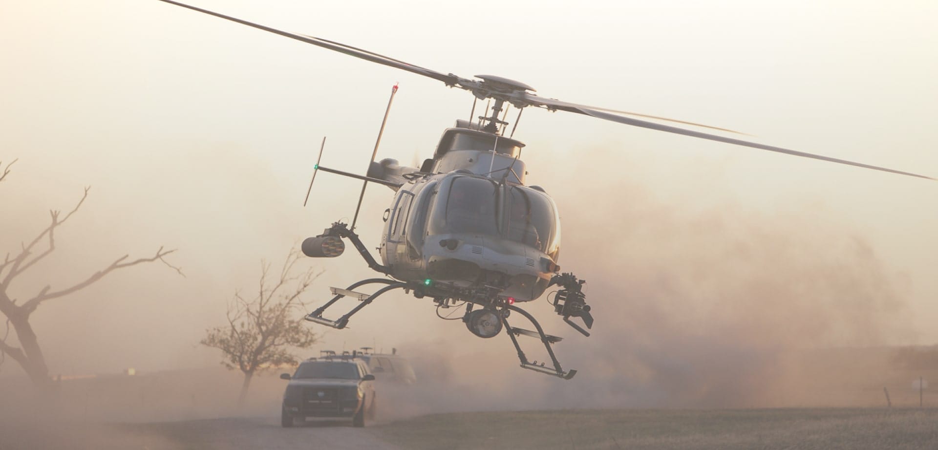 Background image for Helinet Aviation's case study showing a flying helicopter with cars on the road behind it