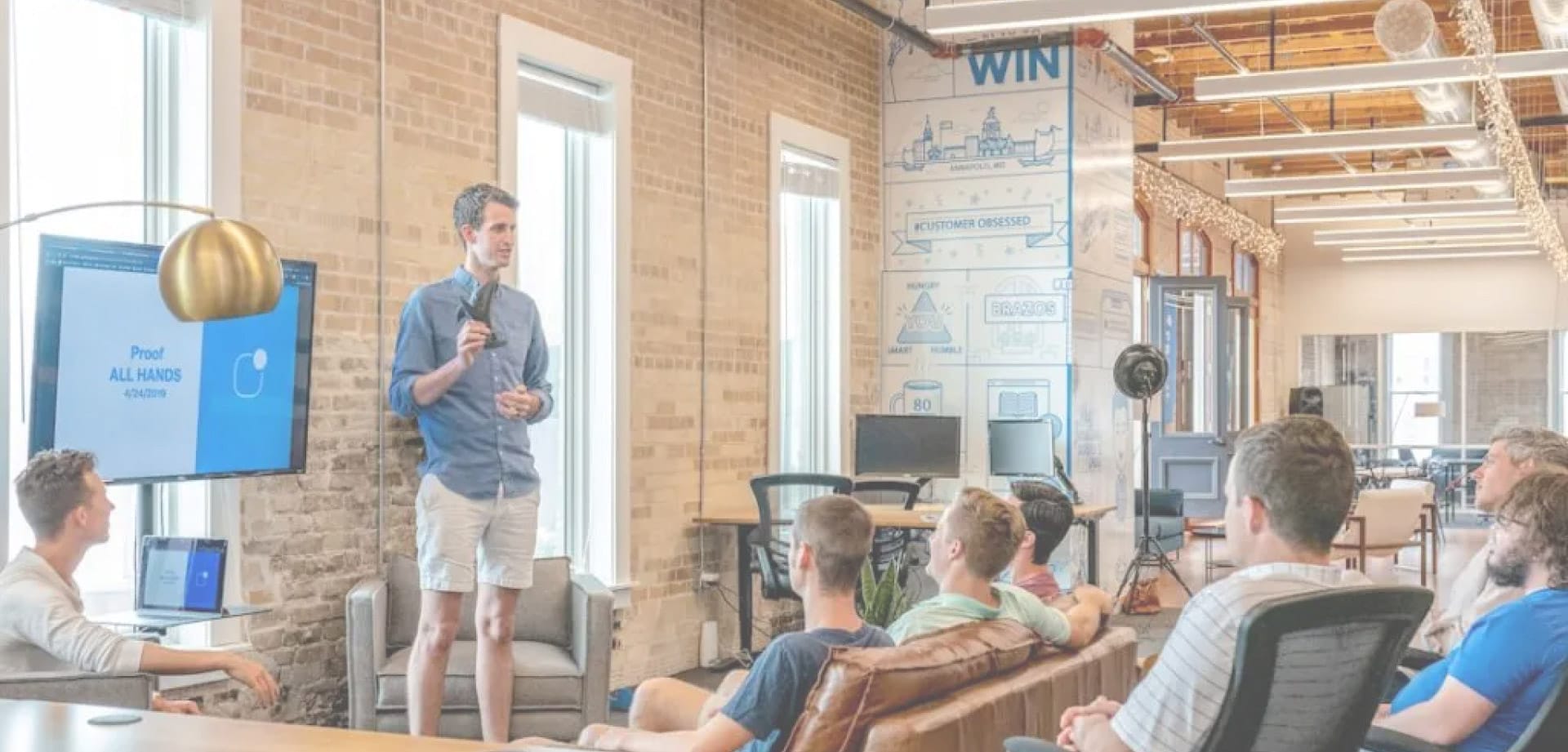 digital-marketing-agency-venture-capital Startup founder presenting to a group in a modern office during a team or investor meeting.